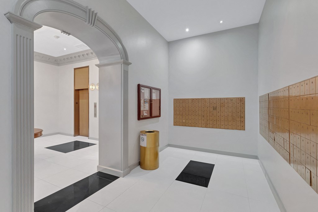 a room with white walls and a white floor with black rugs