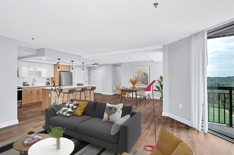 a living room with a couch and a table with a kitchen in the background