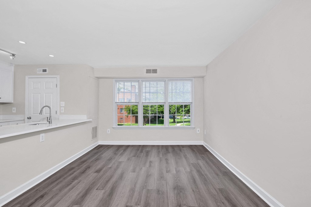 a bedroom with hardwood floors and a large window