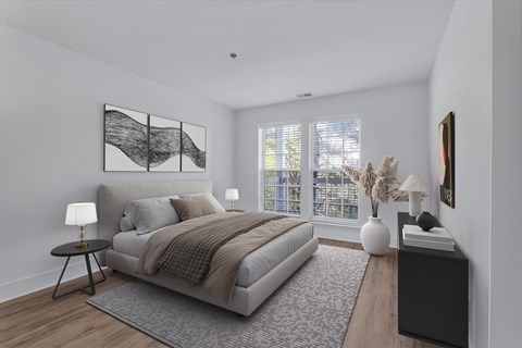 A bedroom with a large bed, a nightstand, and a window with blinds.