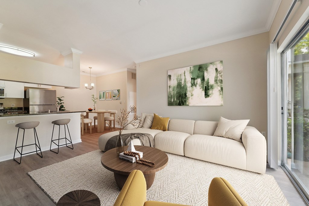 A modern living room with a white sofa, a coffee table, and a painting on the wall.