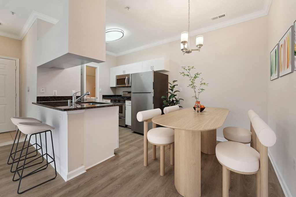 A kitchen with a table and chairs in the middle of the room.