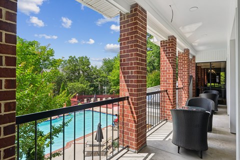 A balcony with a pool and a chair.
