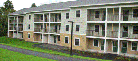 Apartment building with green doors and windows.