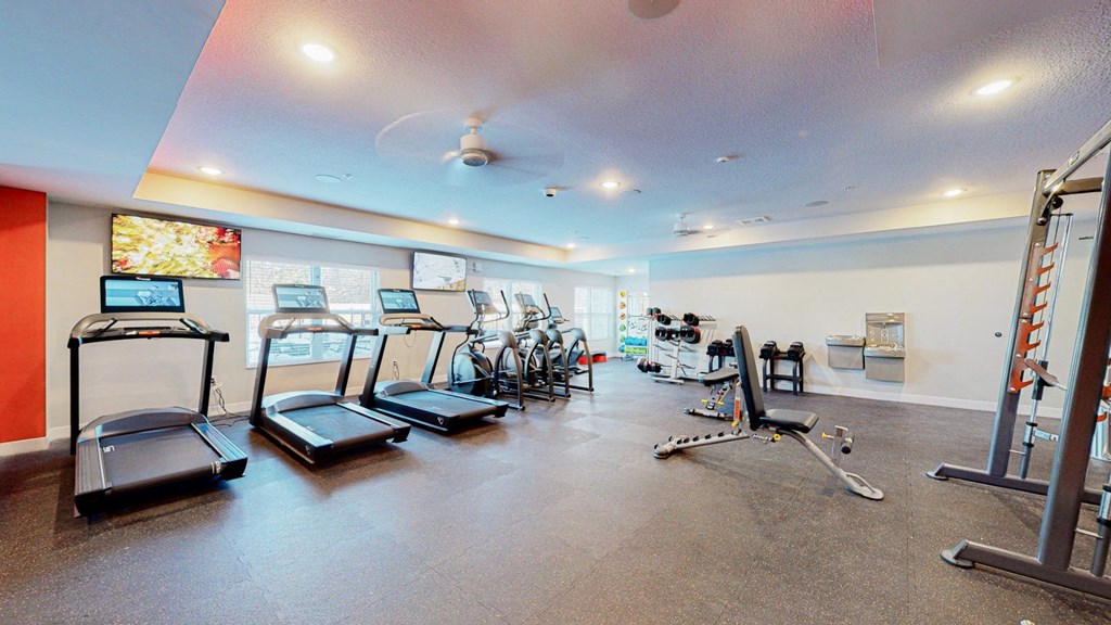 A gym with treadmills, exercise bikes, and other equipment.