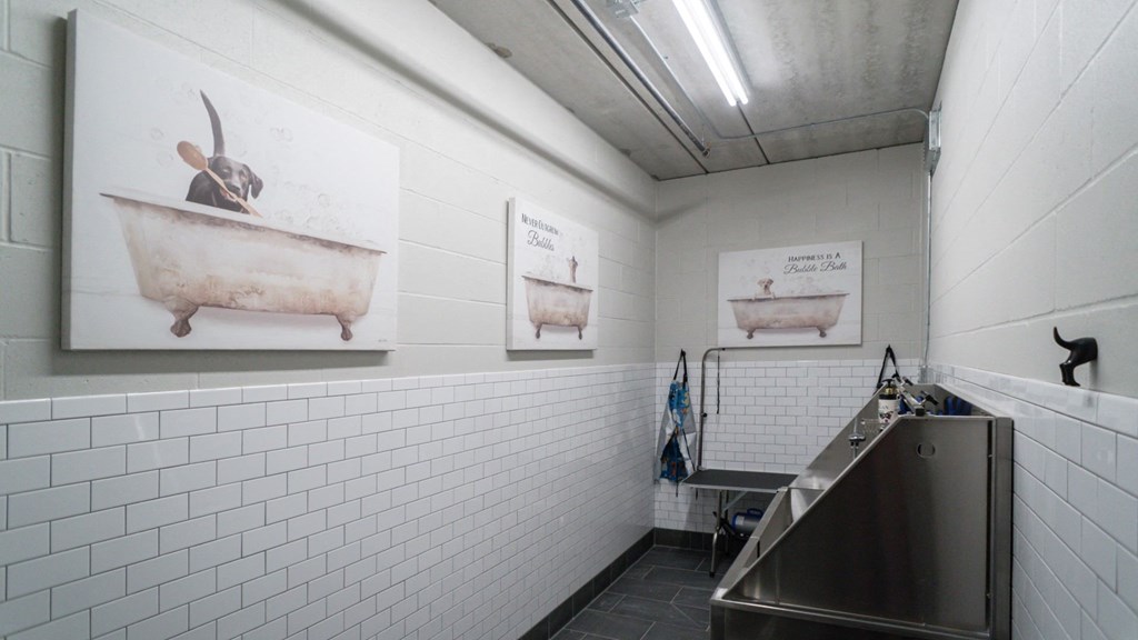 A bathroom with a sink and a picture of a goat in a bathtub.