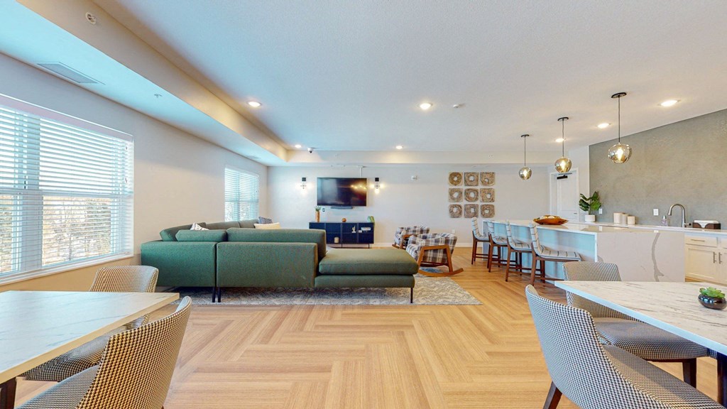 A modern living room with a green sofa and wooden floors.