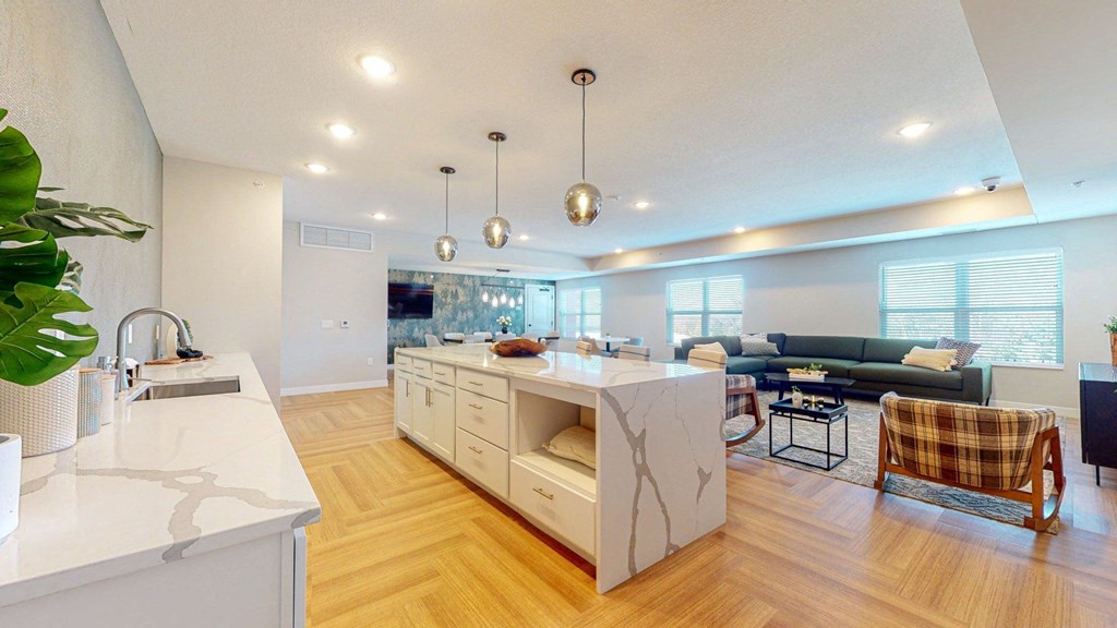 A modern kitchen with a white countertop and wooden flooring.