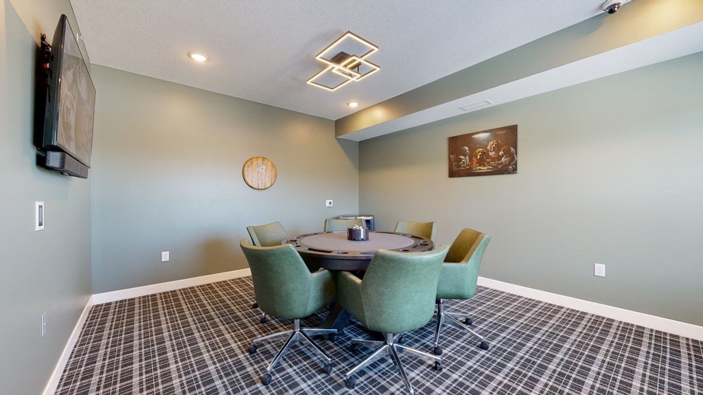 A conference room with a table surrounded by chairs.