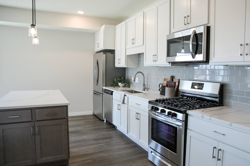 a kitchen with white cabinets and stainless steel appliances