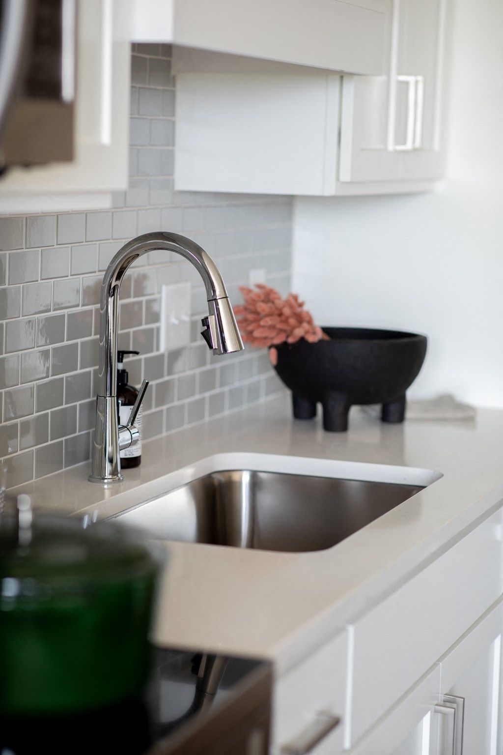 a white kitchen with a sink and a faucet