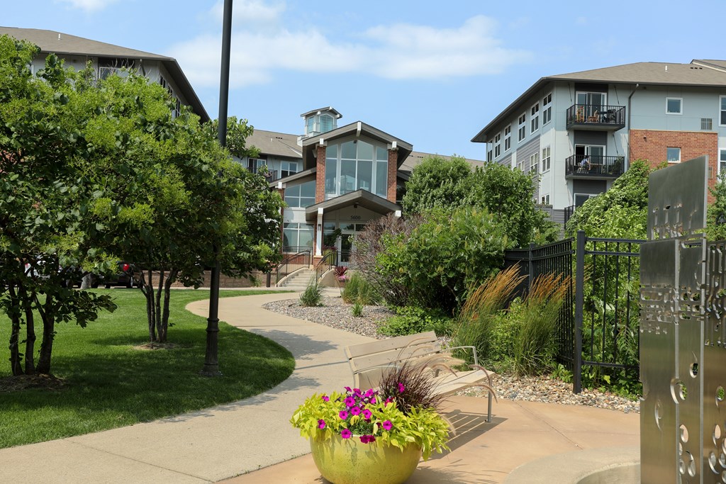 a walkway with benches and buildings in the background