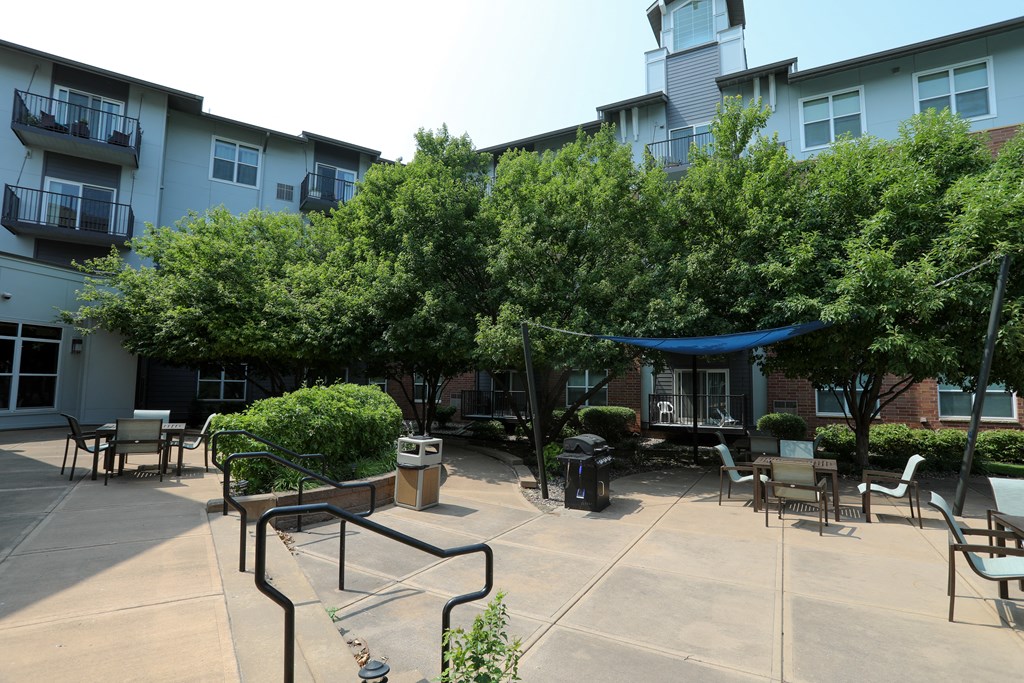 a courtyard with trees and awnings in front of a building