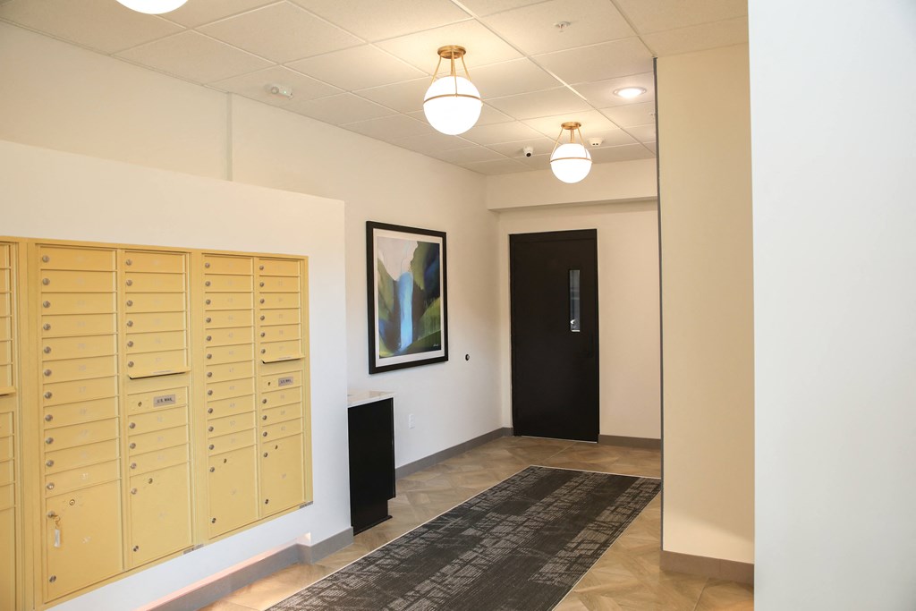 a view of the hallway with lockers and a painting on the wall