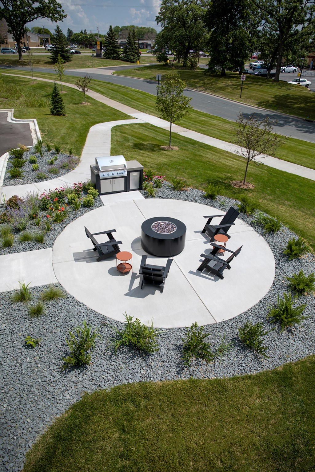 a fire pit and seating area on a concrete patio in a park