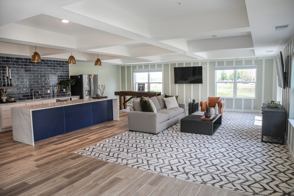 a living room with hardwood floors and a large rug