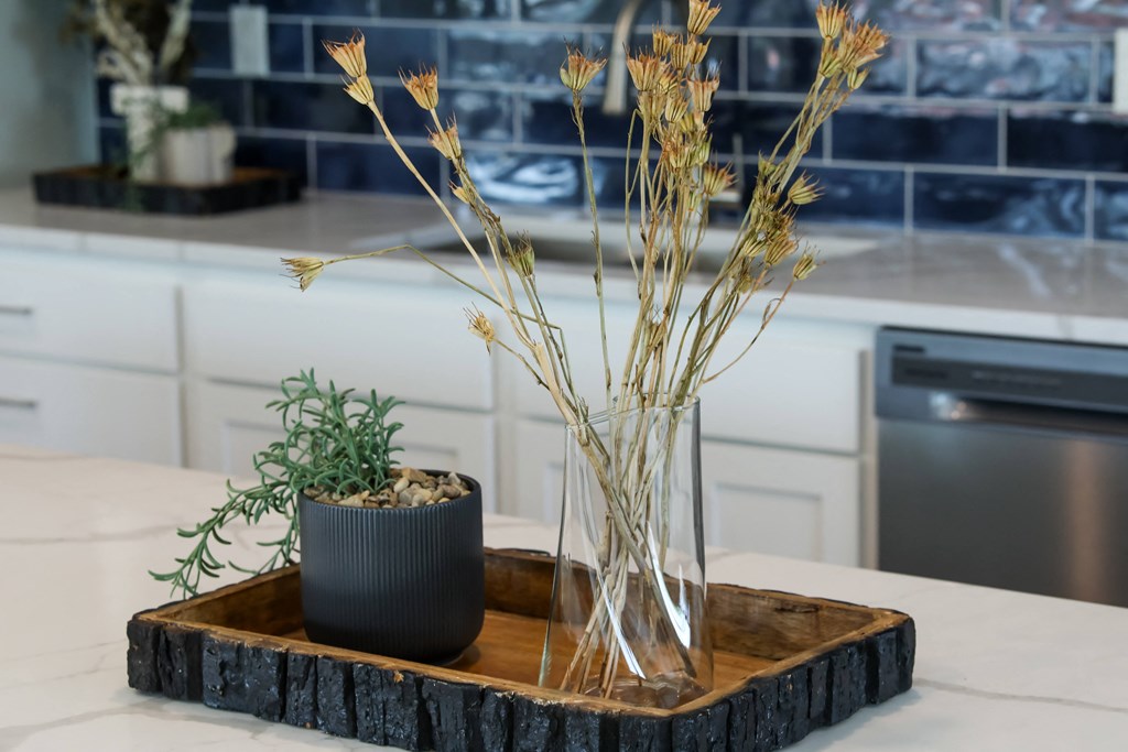 a kitchen with a wooden tray with a vase with flowers on it
