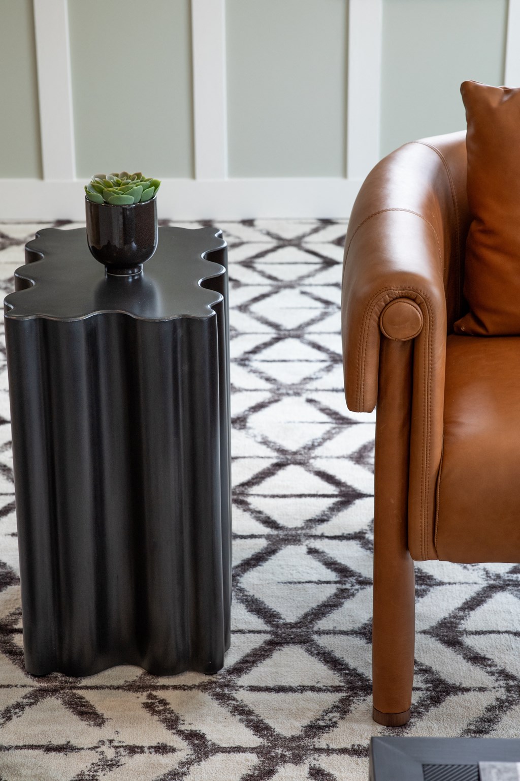 a side table with a black finish and a potted plant on top of it