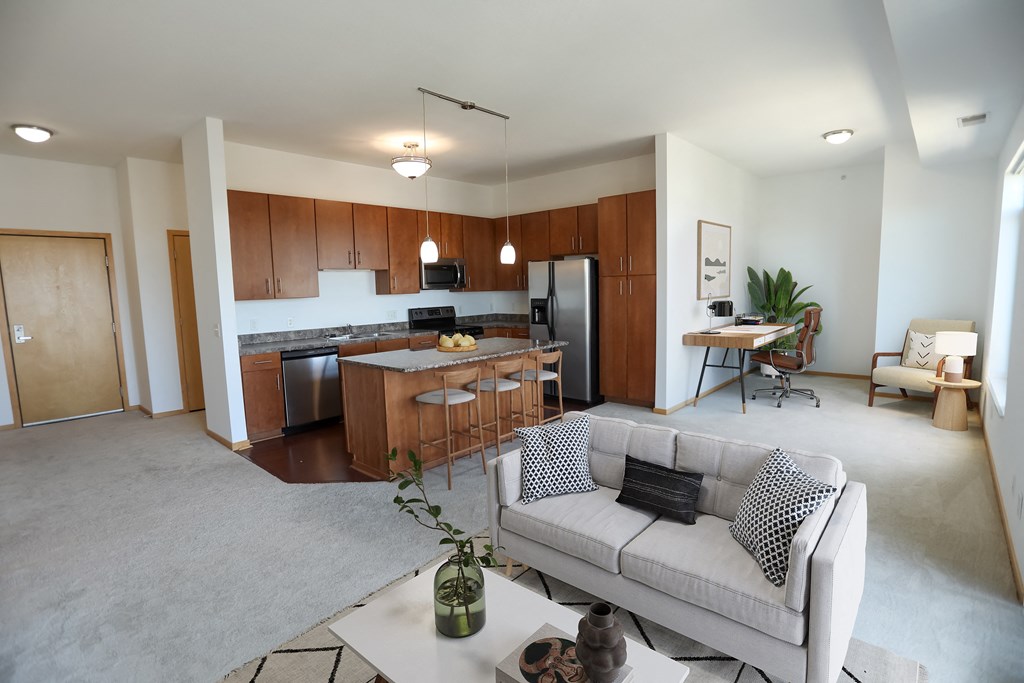 a living room and kitchen with a couch and a table