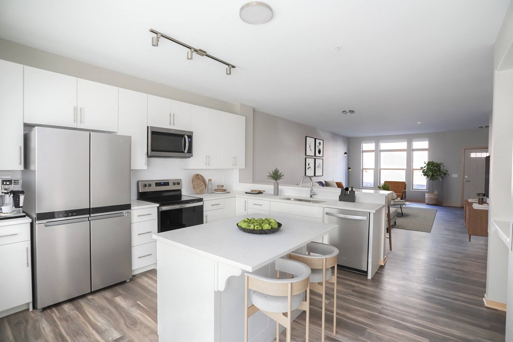 a white kitchen with stainless steel appliances and a white counter top