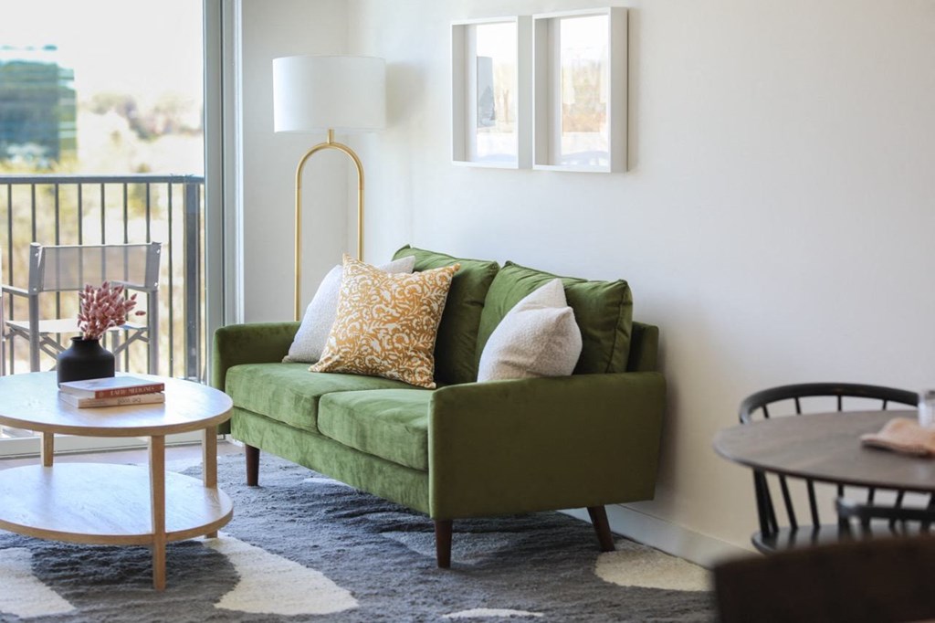 a living room with a green couch and a table