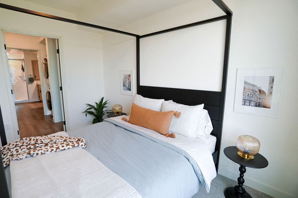 a bedroom with a white bed and a black canopy bed