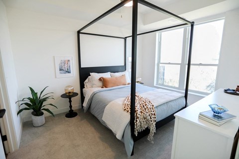 a bedroom with a four poster bed and a large window