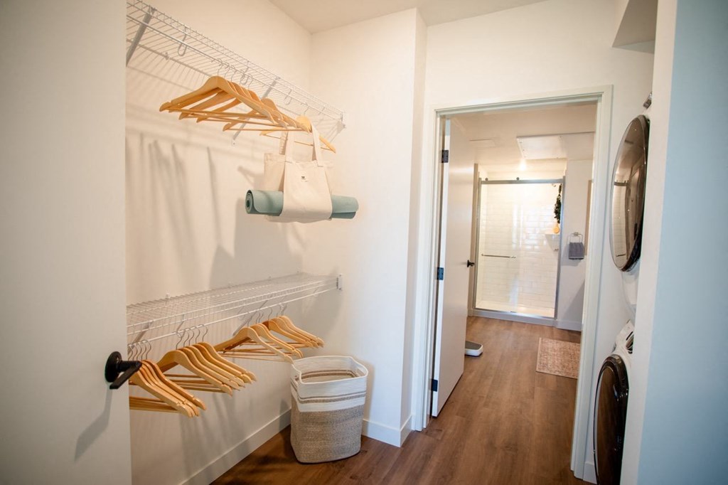 a walk in closet with white walls and a white closet door with a closet organizer
