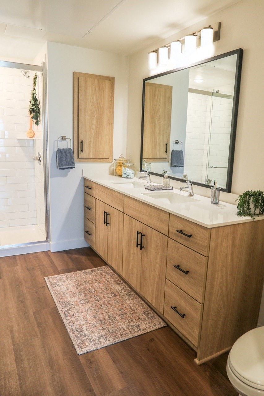 a bathroom with wooden cabinets and a sink and a mirror