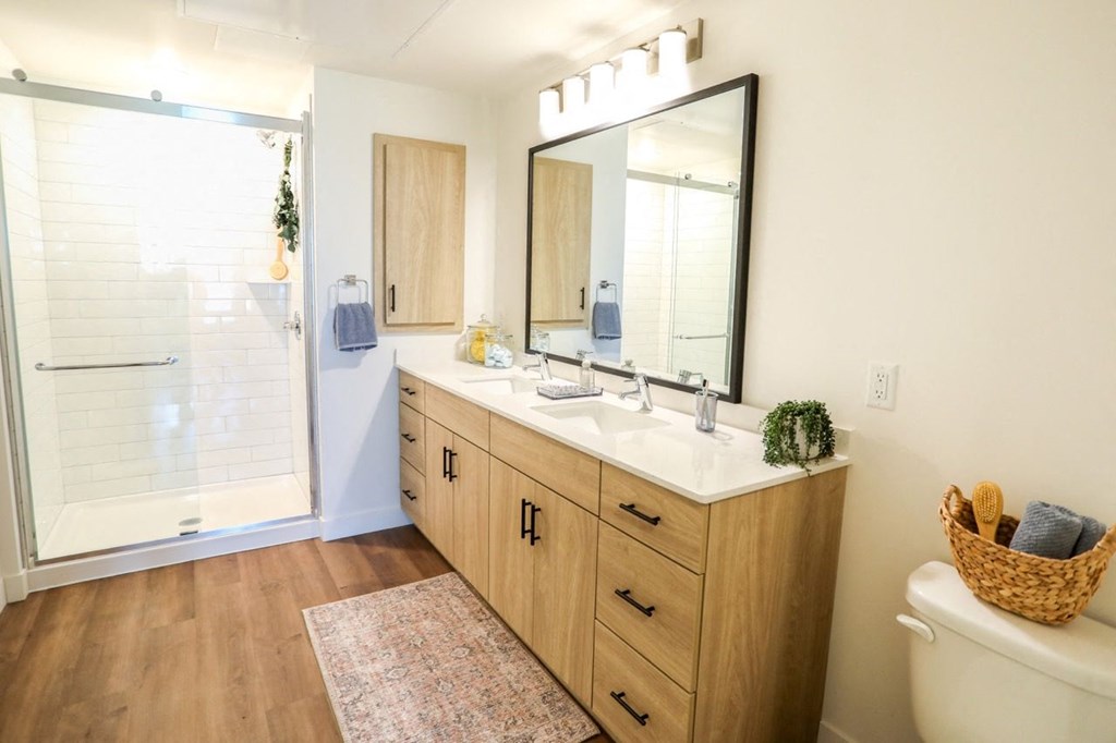 a bathroom with wooden cabinets and a large mirror