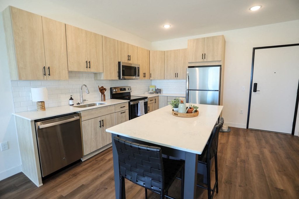 a kitchen with a large island and stainless steel appliances