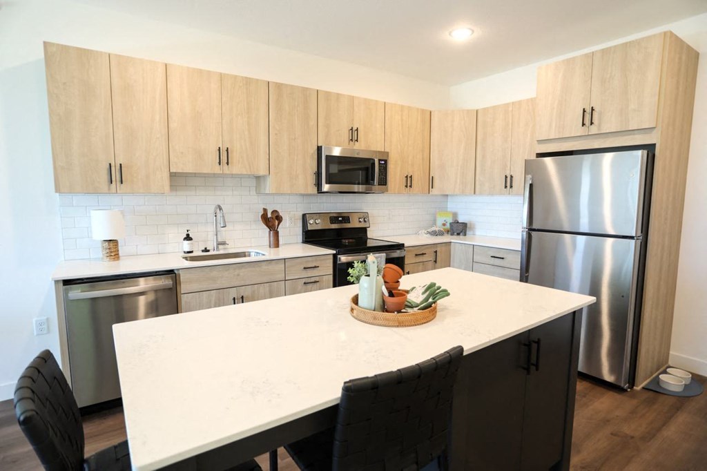 a kitchen with a large island and stainless steel appliances
