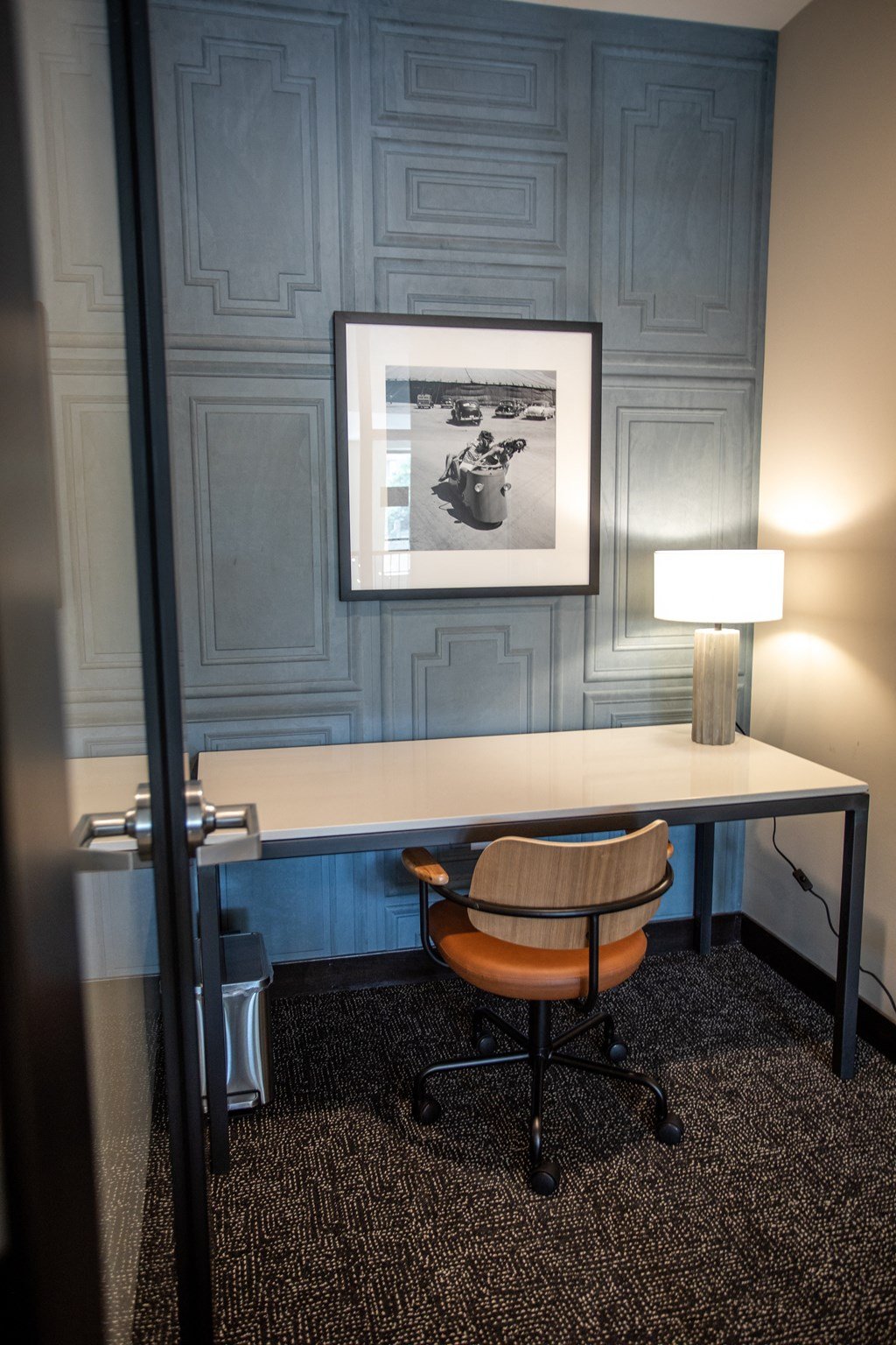 a desk with a chair and a lamp in a room