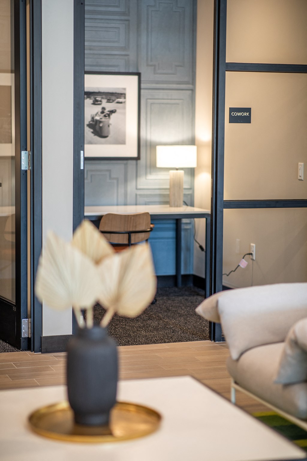 a living room with couches and a table with a vase with a flower