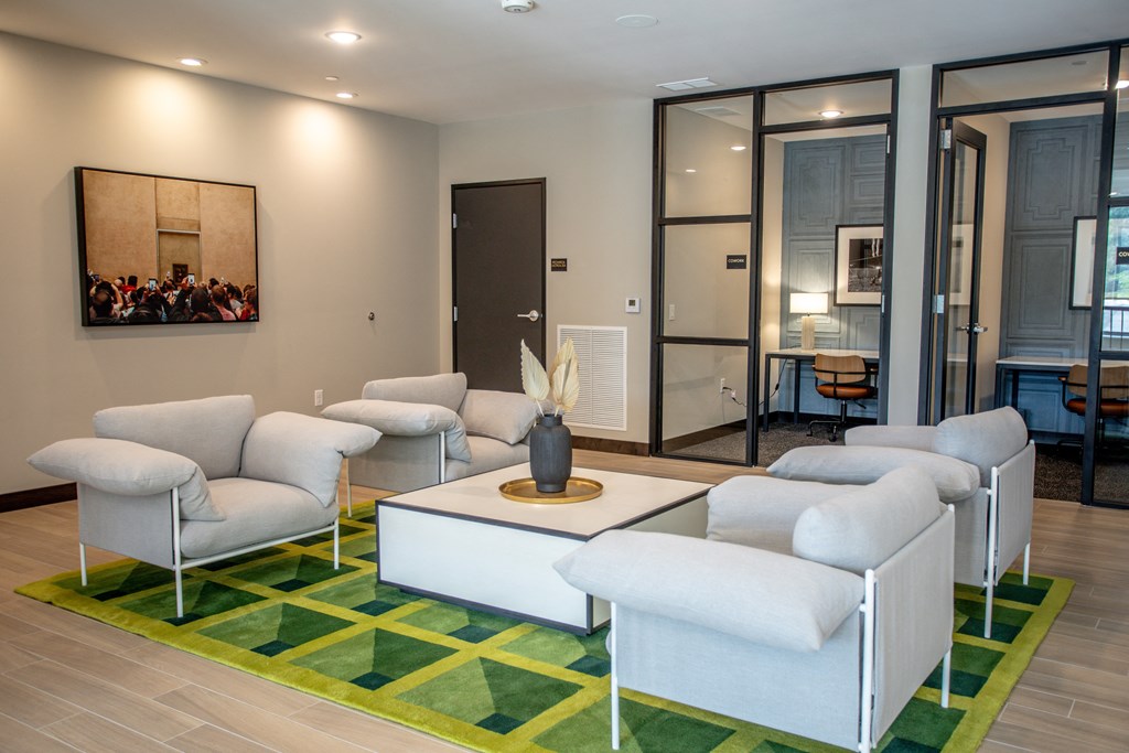a living room with white furniture and a green rug