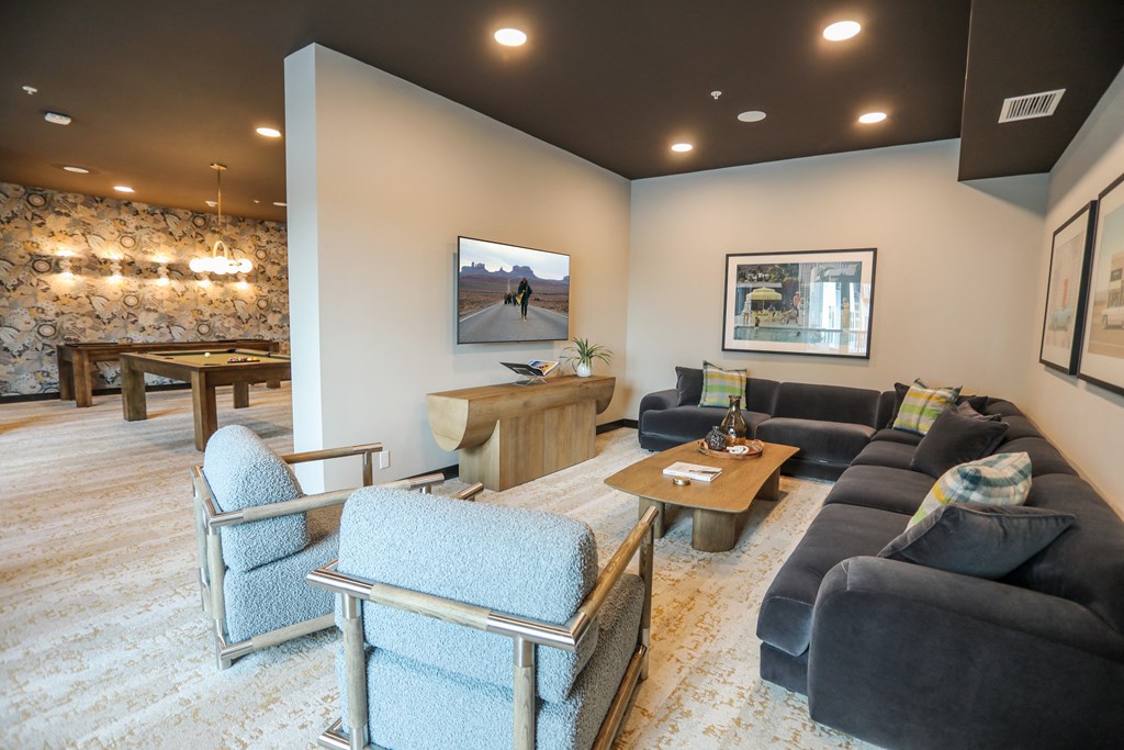 a living room with couches and chairs and a pool table