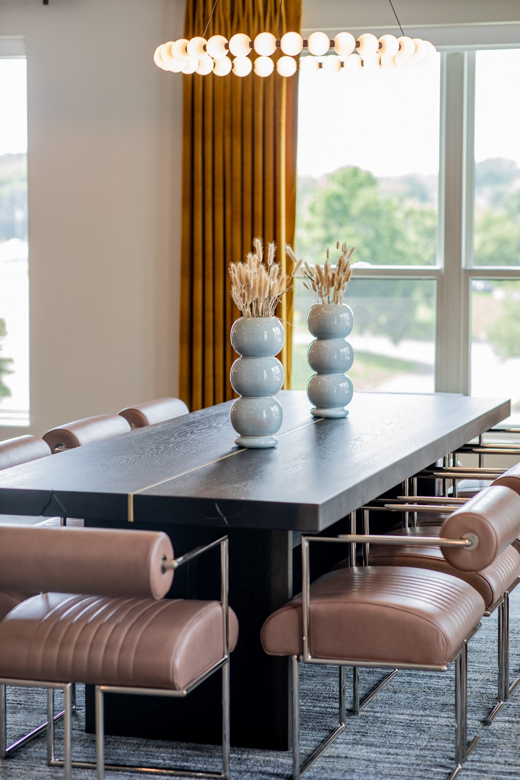 a dining room with a long table and chairs and a large window