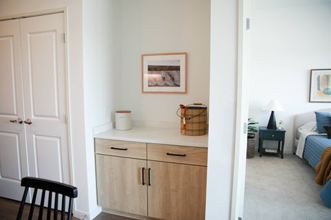 a living room with a counter and a bedroom with a bed