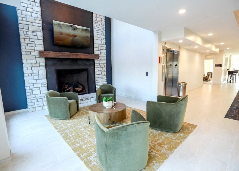 a living room with a fireplace and chairs and a table