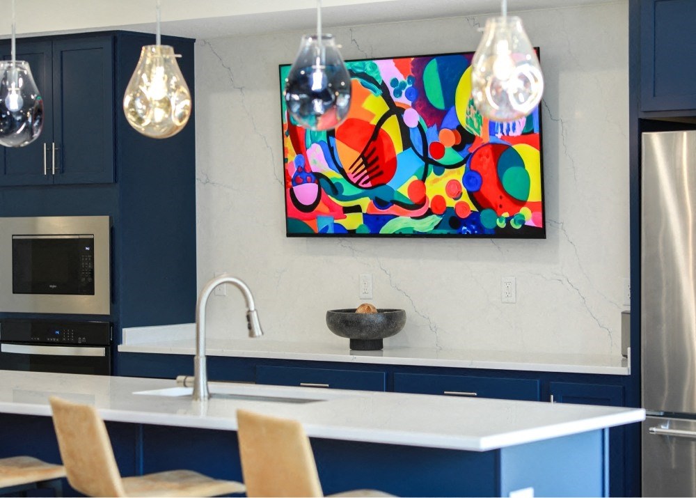 a kitchen with blue cabinets and a painting on the wall