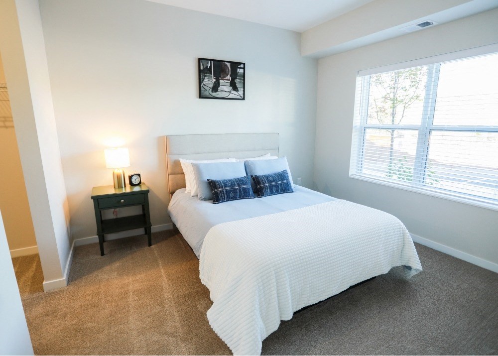 A bedroom with a large bed and a window.
