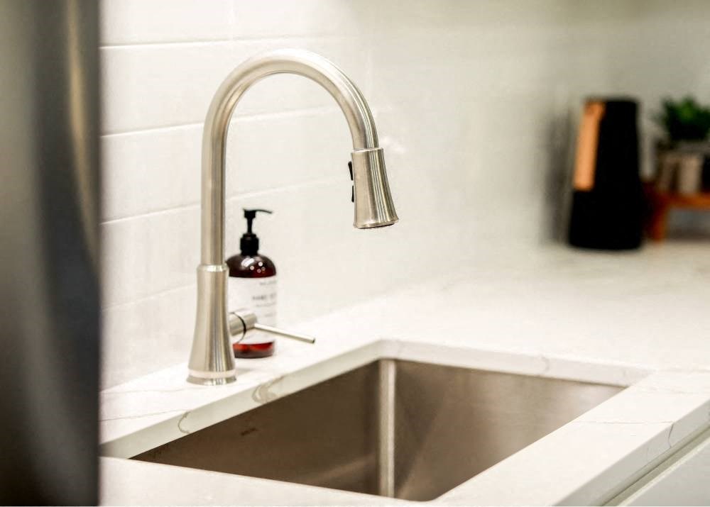 a kitchen sink with a faucet and a bottle of soap on it