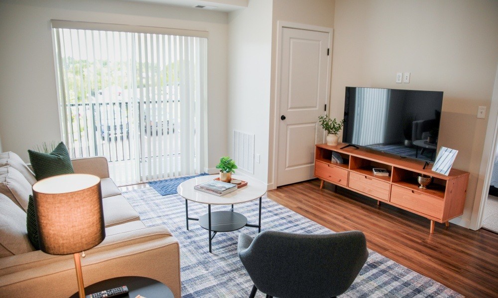 A living room with a couch, chair, and television.