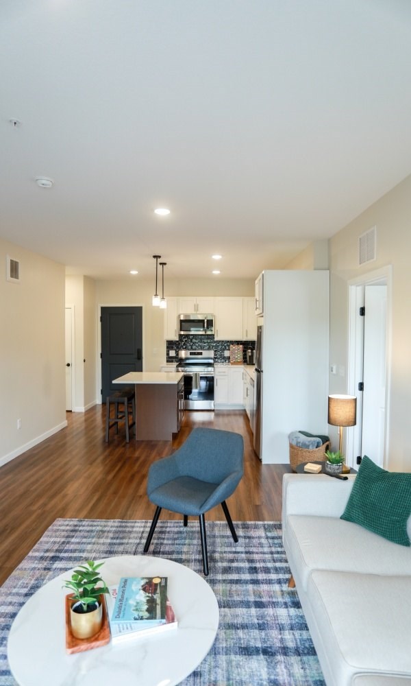 A modern living room with a blue chair and a white coffee table.