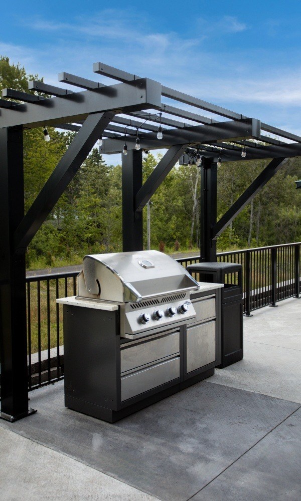 A modern outdoor kitchen with a grill and sink.