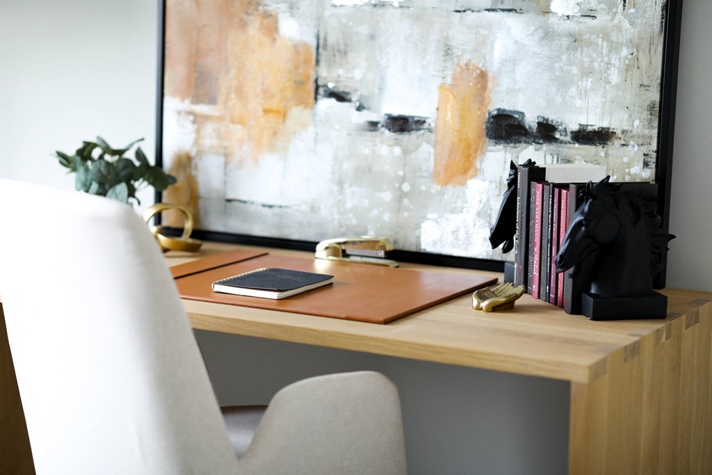a desk with a book and a laptop on it next to a window