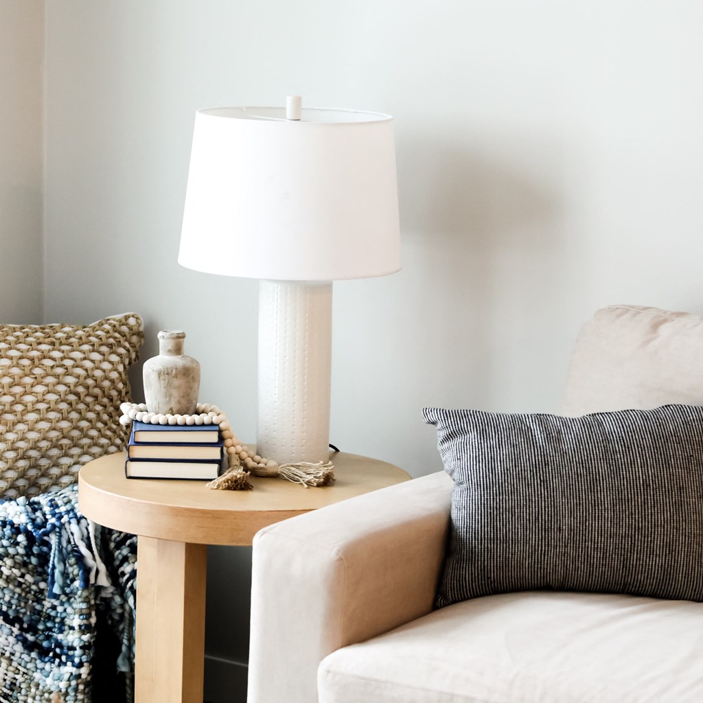 a side table with a lamp and books on it