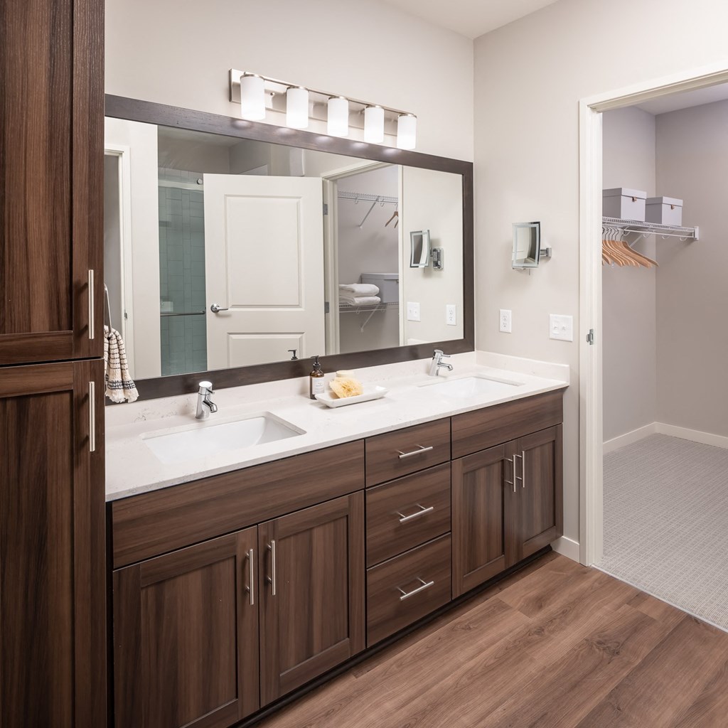 Large bathroom with brown cabinets and quartz countertops