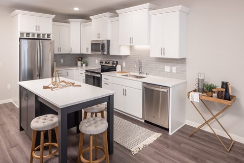 a kitchen with white cabinets and stainless steel appliances
