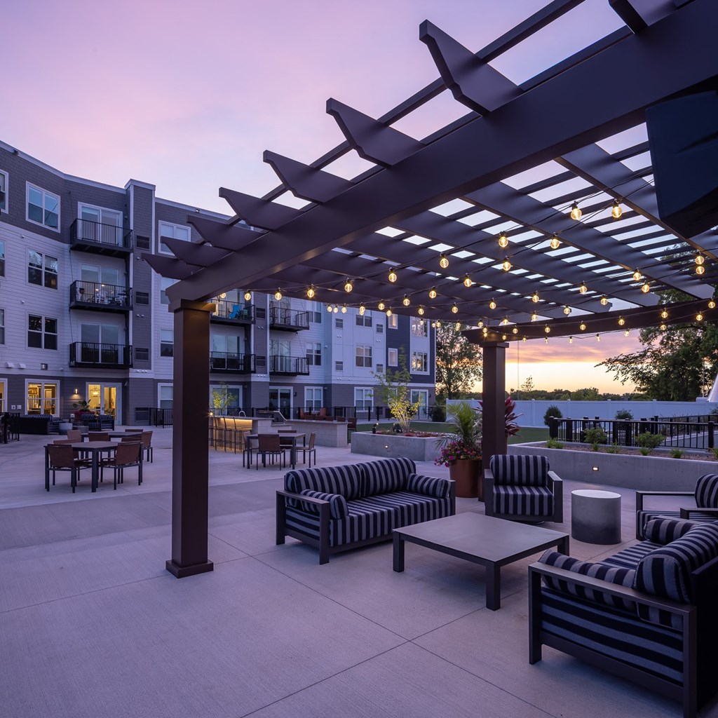 an outdoor patio with couches and tables at dusk